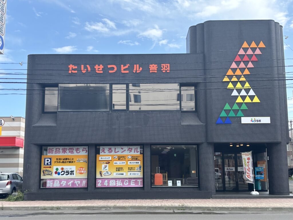 クラポ苫小牧店の店舗外観。たいせつビル音羽の1階にあり、キャッシング・レンカウ・オートローンなどの案内が掲示された黒い外壁の建物。